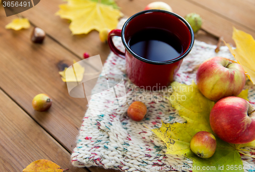 Image of close up of tea cup on table with autumn leaves