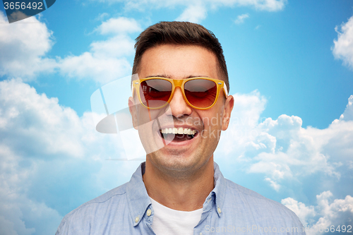 Image of face of smiling man in shirt and sunglasses