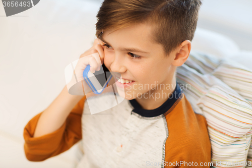 Image of happy boy calling on smartphone at home