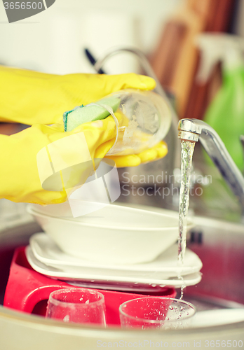 Image of close up of woman hands washing dishes in kitchen