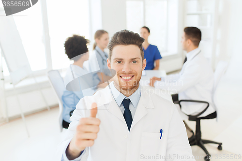 Image of happy doctor over group of medics at hospital