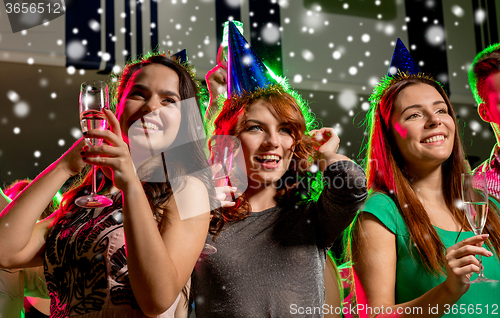 Image of smiling friends with glasses of champagne in club