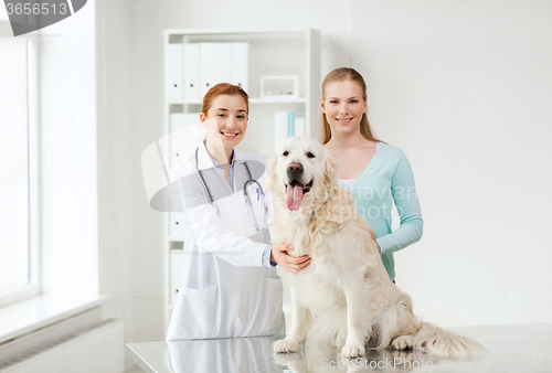 Image of happy woman with dog and doctor at vet clinic