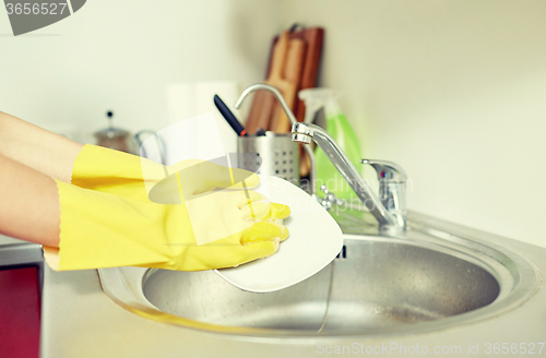 Image of close up of woman hands washing dishes in kitchen