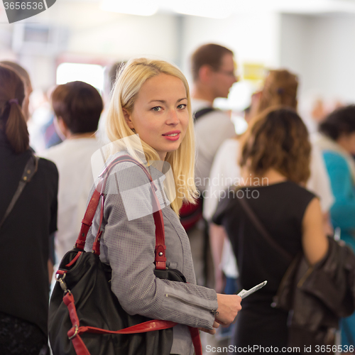 Image of Young blond caucsian woman waiting in line.