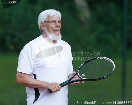 Image of Senior man playing tennis