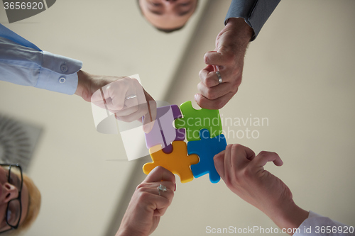 Image of business people group assembling jigsaw puzzle