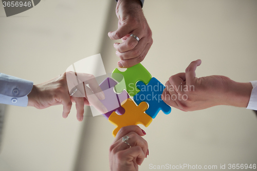 Image of business people group assembling jigsaw puzzle