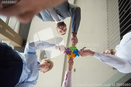 Image of business people group assembling jigsaw puzzle