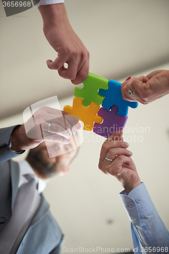 Image of business people group assembling jigsaw puzzle