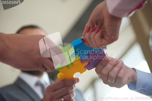 Image of business people group assembling jigsaw puzzle