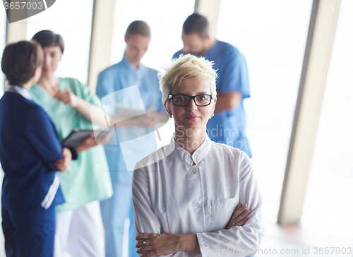 Image of female doctor with glasses and blonde hairstyle standing in fron