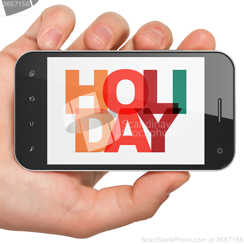 Image of Entertainment, concept: Hand Holding Smartphone with Holiday on  display