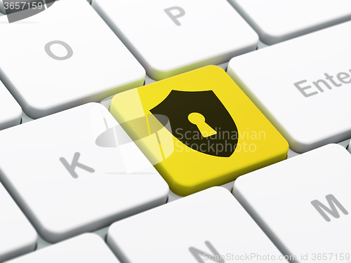 Image of Security concept: Shield With Keyhole on computer keyboard background