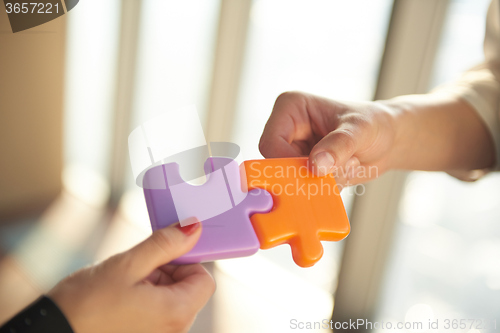 Image of business people group assembling jigsaw puzzle