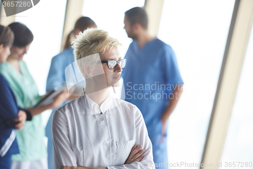 Image of female doctor with glasses and blonde hairstyle standing in fron