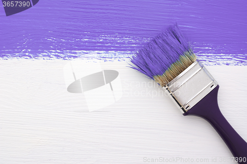 Image of Stripe of purple paint with a paintbrush on white