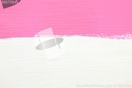 Image of Stripe of pink paint over white wooden background