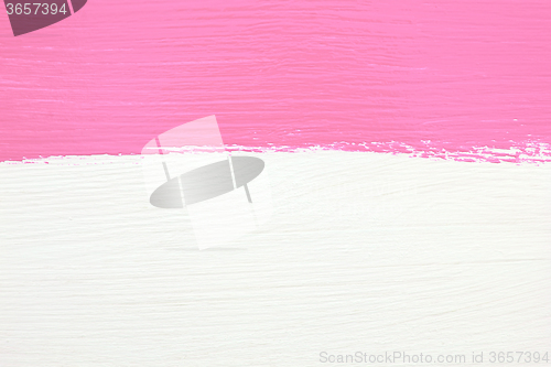 Image of Stripe of pink paint over white wooden background