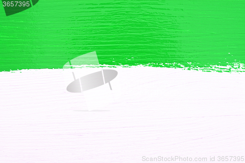 Image of Stripe of green paint over white wooden background