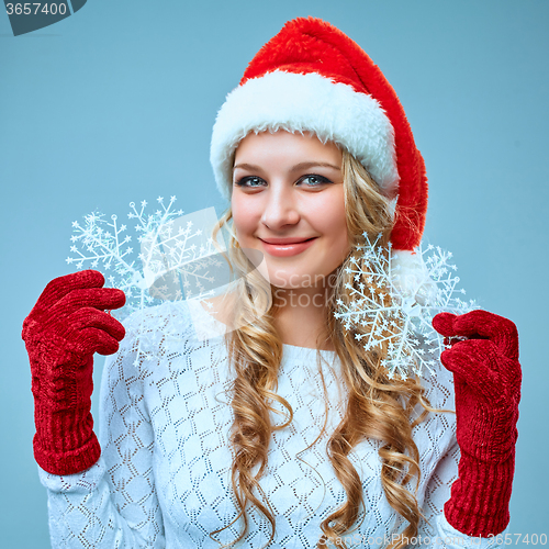 Image of Beautiful young woman in Santa Claus clothes with snowflakes