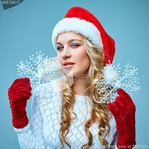 Image of Beautiful young woman in Santa Claus clothes with snowflakes