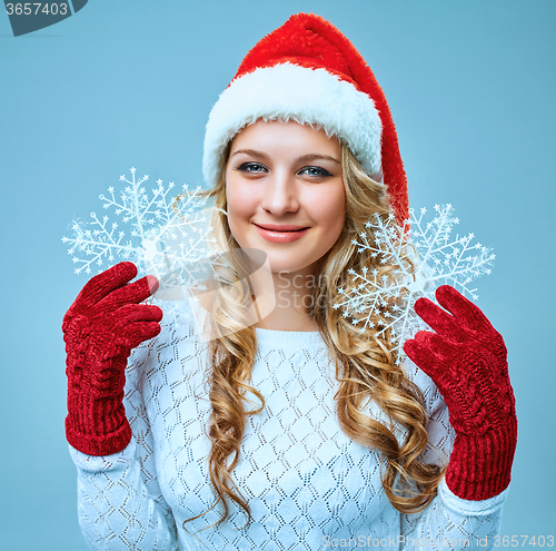 Image of Beautiful young woman in Santa Claus clothes with snowflakes