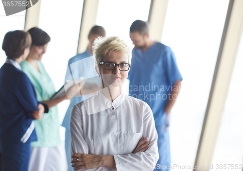 Image of female doctor with glasses and blonde hairstyle standing in fron