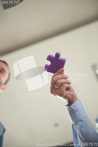 Image of business people group assembling jigsaw puzzle