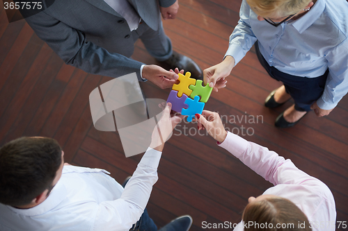 Image of business people group assembling jigsaw puzzle