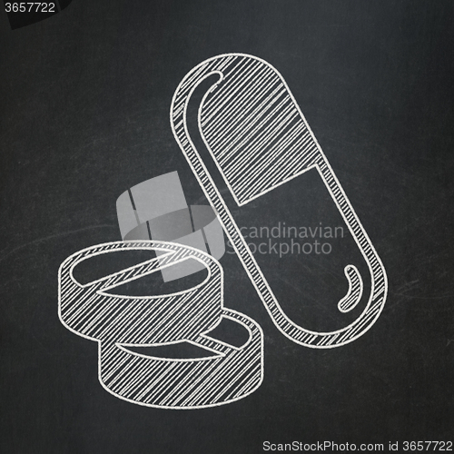 Image of Medicine concept: Pills on chalkboard background