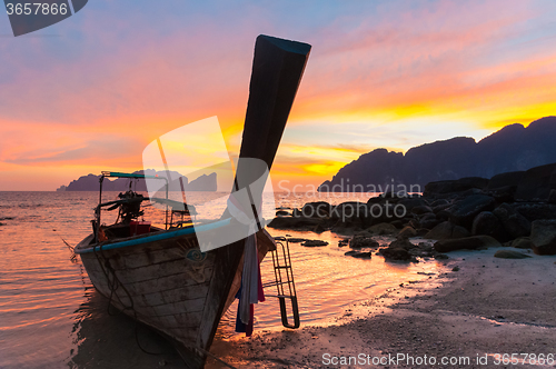 Image of Traditional wooden longtail boat on beach in sunset, Thailand.