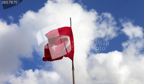 Image of Turkish flag on flagpole waving in wind