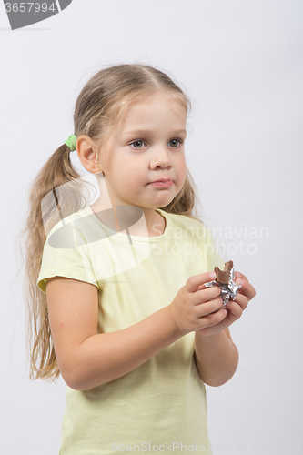 Image of Portrait of a four-year girl with chocolate in hand