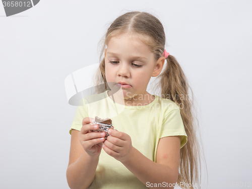 Image of Four-year girl eats a chocolate sweet tooth