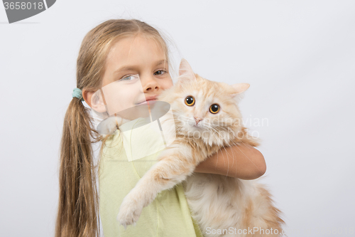 Image of Six year old girl with a cat in her arms