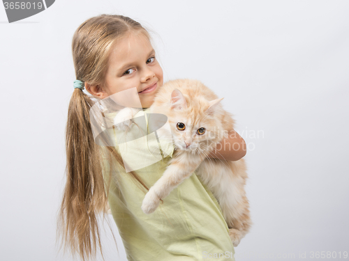 Image of Six year old girl holding a cat in her arms