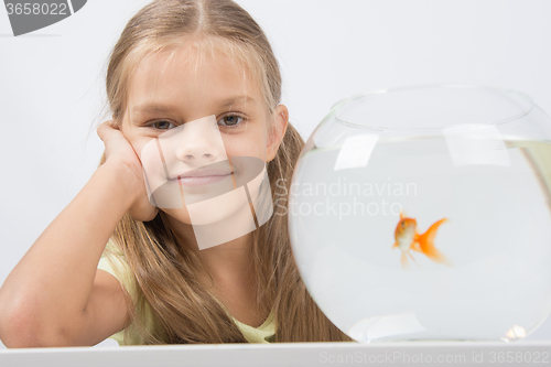 Image of Happy six year old girl with an aquarium and a goldfish