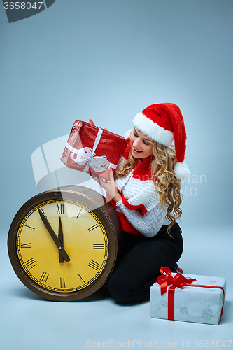 Image of Girl dressed in santa hat holding with a Christmas decorations  