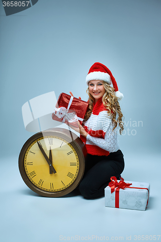 Image of Girl dressed in santa hat holding with a Christmas decorations  