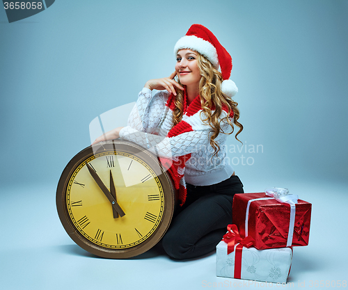 Image of Girl dressed in santa hat holding with a Christmas decorations  