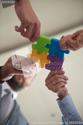 Image of business people group assembling jigsaw puzzle