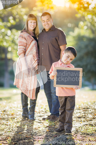 Image of Mixed Race Couple Stands Behind Son with Blank Chalk Board