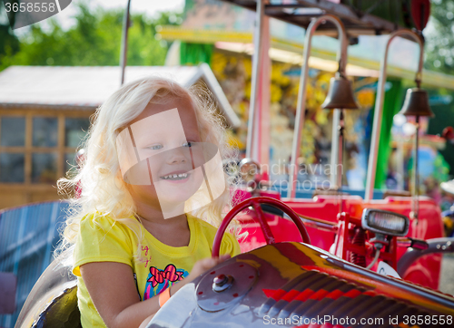 Image of The child goes for a drive on a children\'s attraction