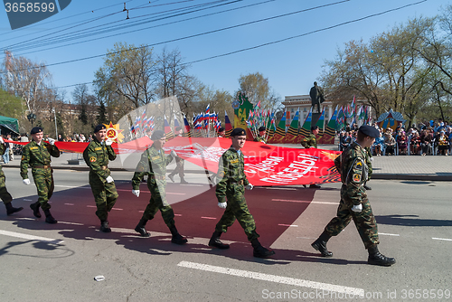 Image of Cadets of patriotic club go on parade with flag