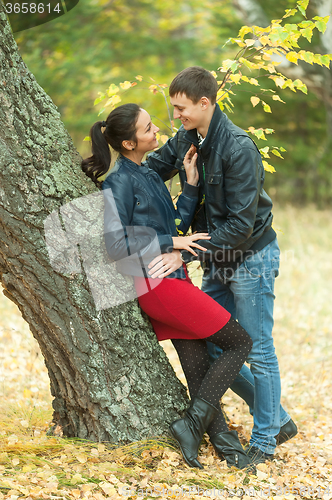 Image of Affectionate couple taking walk in autumn park