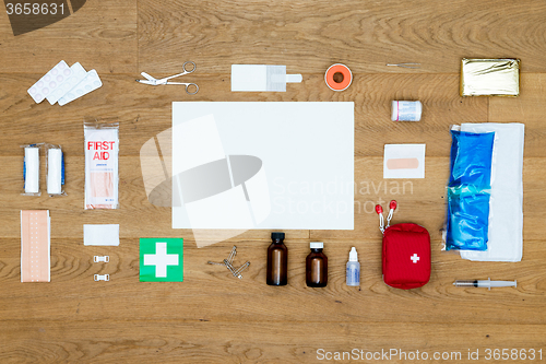 Image of First Aid kit items aligned on wooden surface with copy space ar