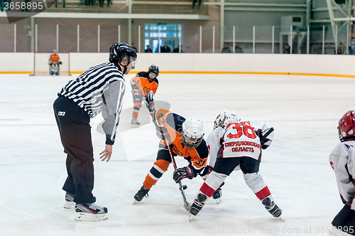 Image of Puck playing between players of ice-hockey teams