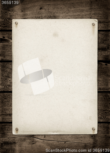 Image of Old textured paper sheet on a dark wood table
