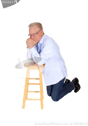 Image of Older man kneeling and praying.